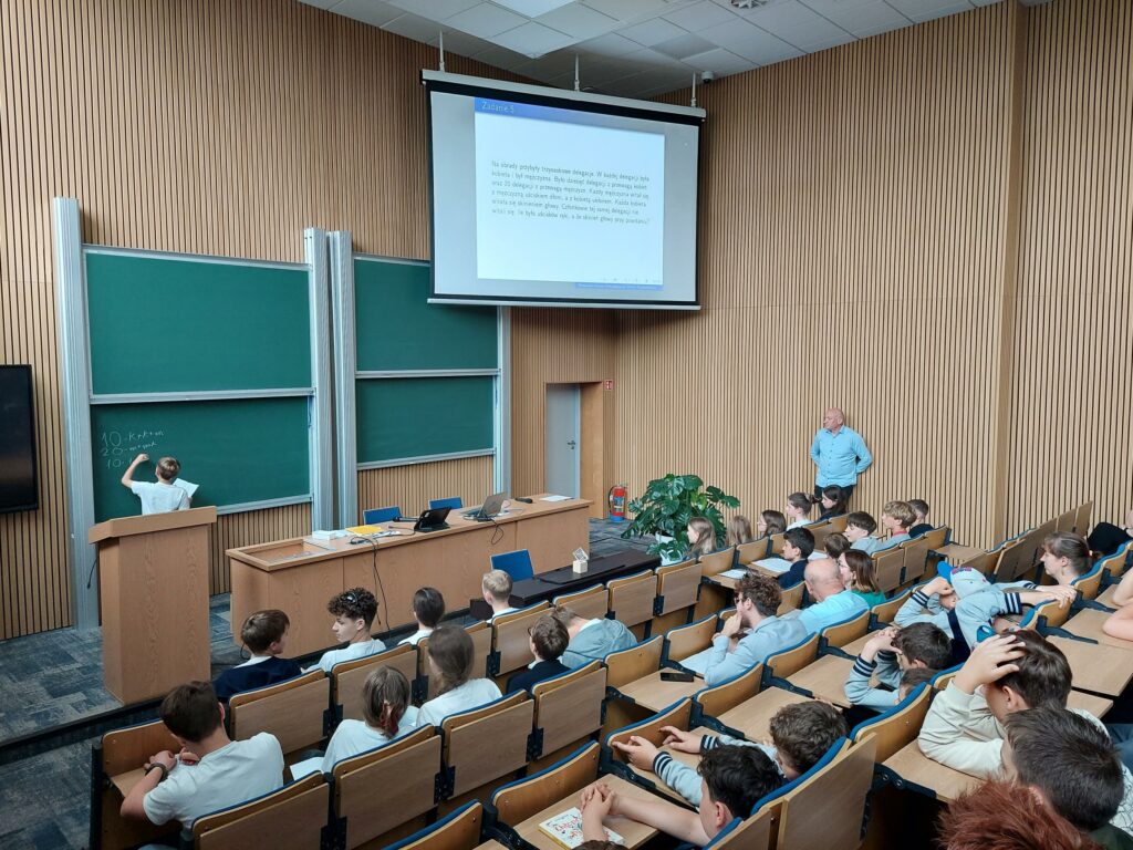 uczestnik przy tablicy z zadaniem matematycznym, widok od góry