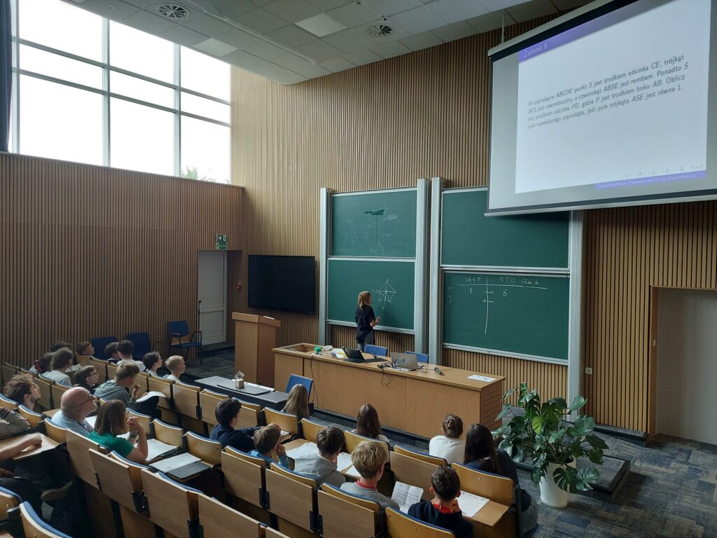 uczestniczka przy tablicy z zadaniem matematycznym, widok od góry
