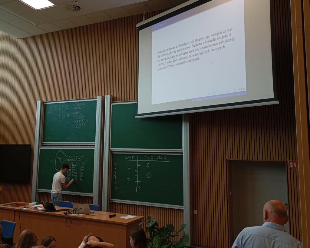uczestnik przy tablicy z zadaniem matematycznym